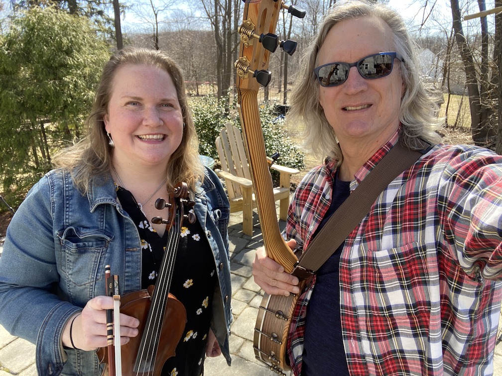 photo of Long Lost String Band - Anne Rouillard with a fiddle on the left and Chris Reckling with a banjo on the right.